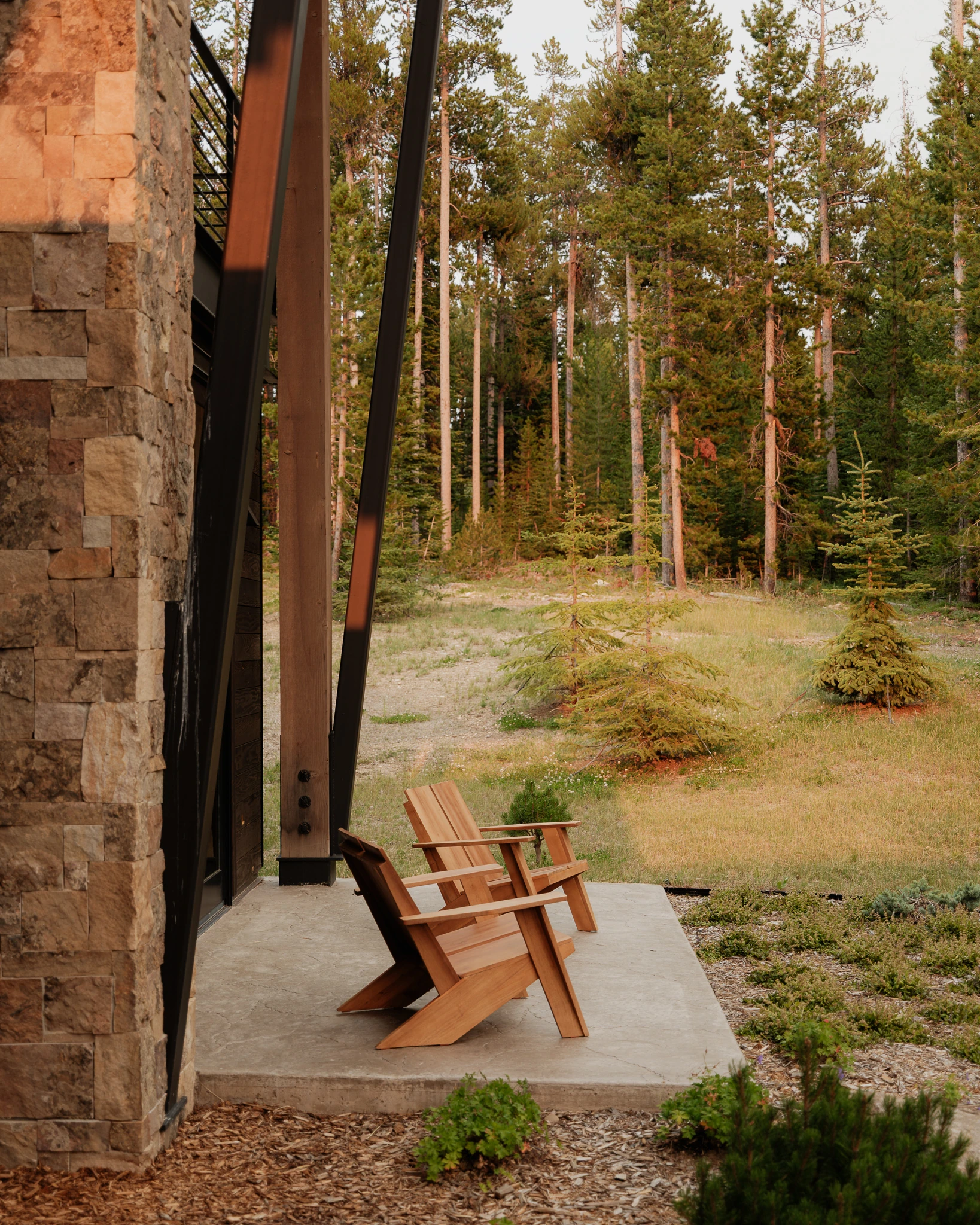 Covered patio with Adirondack chairs among the pines — architectural photography Big Sky Montana, Speedwell Cabin